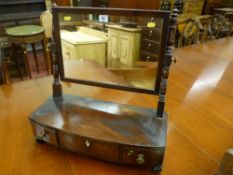 A Georgian mahogany swing toilet mirror, the mirror with turned supports, the base with three frieze