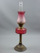 A Victorian oil lamp with cranberry glass font and Art Nouveau style etched shade with cranberry