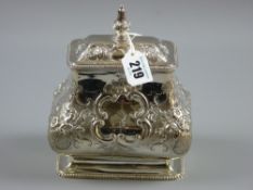 A fine oblong based silver tea caddy of shaped form, the body heavily scrolled with front and rear