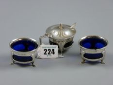 A three piece Art Nouveau style cruet set of two open and one lidded holder with blue glass liners