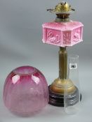 A circular based brass Corinthian column oil lamp with pink milk glass square reservoir having
