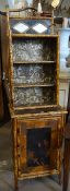 A colonial style bamboo cabinet with upper shelves and mirrored top and with painted lacquer-work