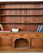 A large turn of the century Welsh dresser composed of base flanked by cupboards either side, three