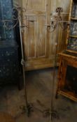 A pair of elaborate metallic standing candelabra with four sweeping branches and on scrolling tripod