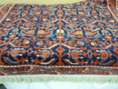 An Oriental washed woollen rug with tasselled ends, all over geometric design with narrow border,