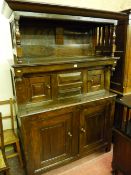 An 18th Century Welsh oak cwpwrdd tridarn having a hooded top with cornice and turned pillars over a