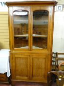 A late 19th/early 20th Century two piece oak standing corner cupboard, the upper section having