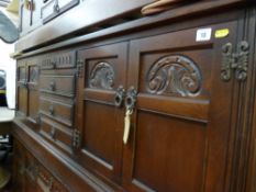 A reproduction Priory style sideboard with four central drawers and flanking twin door cupboards