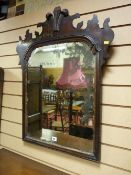 A late 18th Century mahogany wall mirror with shaped top frieze and carved central Prince of Wales