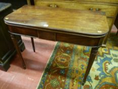 A William IV mahogany foldover tea table with front turned supports and retracting rear supports