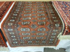 A hand knotted 100% pile Pakistan runner, wide bordered on a red ground with repeating full length