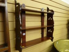 An Edwardian mahogany three shelf rack with fretwork floral ends