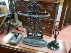 A cast iron black painted oval stickstand, a black painted cast iron doorstop with lion base and a