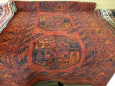 A red ground Eastern woollen runner with stylized geometric pattern and borders, 107 x 275 cms