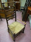 A Lancashire style elm rocking chair with rush seat, turned top rail and arms with turned front