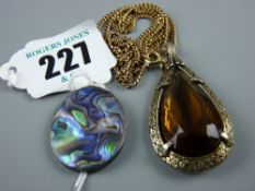 A nine carat gold fine link chain with a yellow metal framed pear shaped amber stone pendant and