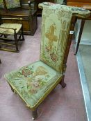 An Edwardian mahogany prie-dieu chair, the tapestry back with a cross amongst flowers, the seat with