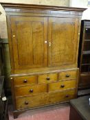 A 19th Century two piece oak press cupboard having a stepped cornice over two doors and a base of