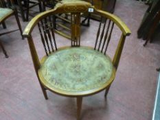 An Edwardian inlaid mahogany tub chair with spindle galleried back, upholstered oval seat on