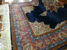 A 20th Century Eastern woollen rug with tasselled ends, red bordered with floral pattern, the centre