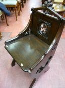 A late 19th Century Gothic style oak hall chair with leaf carved top rail, carved pierced back and