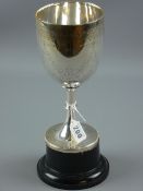 A Victorian bright cut uninscribed silver trophy cup on a black plinth, 22 cms high, 13 troy ozs,