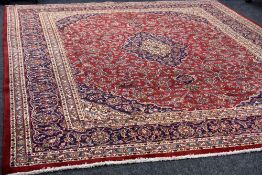 A LARGE RED GROUND PERSIAN KASHAN CARPET, multi-coloured traditional design, 384 x 296 cms