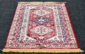 RED GROUND CASHMERE RUG in medallion design, 170 x 116 cms