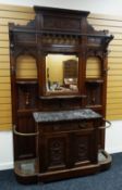 A LARGE EDWARDIAN HALL/COAT STAND with mirrored centre above a marbled topped cupboard base with