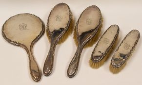 FIVE PIECE SILVER DRESSING-TABLE SET with centre monogram and of plain form with crimped borders,