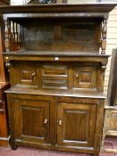 An 18th Century Welsh oak cwpwrdd tridarn having a hooded top with cornice and turned pillars over a