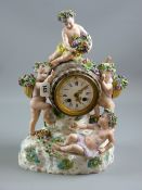 Meissen porcelain - a figural mantel clock with barrel clock housing on a floral encrusted and