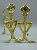 A PAIR OF ARTS & CRAFTS HAND IRONS in the form of stylized flowers, the head set with Ruskin type