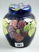 A MOORCROFT CLEMATIS GINGER JAR, a 15 cms high ginger jar and cover decorated on a cobalt blue