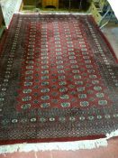 AN IRANIAN CARPET, red ground classically styled with tasselled ends, 286 x 190 cms approximately