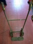 AN ANTIQUE IRON RAILWAY PLATFORM TRUCK with wooden grips and iron spoke wheels, 92 x 39 cms