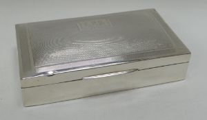 A SILVER CIGARETTE BOX machine decorated with monogrammed Art Deco style cartouche, Chester 1935,