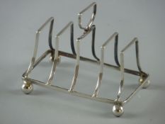 A FOUR COMPARTMENT SILVER TOAST RACK on corner ball feet, 1.7 ozs, Birmingham 1908
