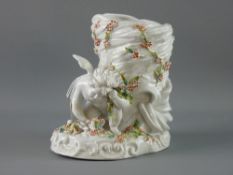 A CONTINENTAL PORCELAIN CHERUB VASE depicting a two winged cherub kneeling before a basket