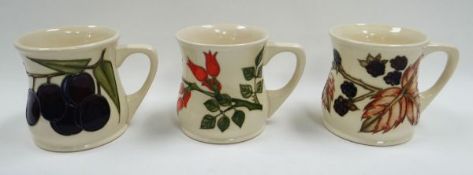 THREE MOORCROFT MUGS with flower or fruit decoration, circa 1993
