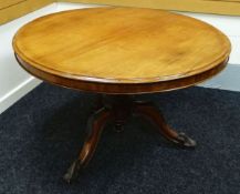 A CIRCULAR TILTING TEA-TABLE on a carved tripod base, 118cms diam