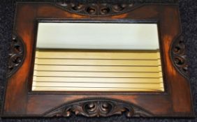 A CARVED OAK FRAMED BEVELLED MIRROR, 59 x 78cms