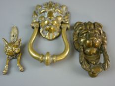 A HEAVY LION'S MASK DOOR KNOCKER, 23 cms long, a further similar, 17 cms long and a brass fox door