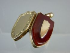 A VICTORIAN YELLOW METAL SHIELD SHAPED PENDANT PHOTO LOCKET, having a bloodstone front with small