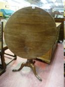 A 19th CENTURY CIRCULAR TOPPED MAHOGANY TRIPOD TABLE having a turned centre pillar to three