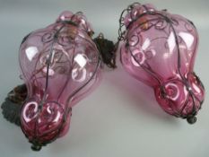 A PAIR OF VENETIAN STYLE HALL LANTERNS, wrought iron scroll work frames with cranberry effect
