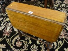 AN EDWARDIAN MAHOGANY SUTHERLAND TABLE on ring turned supports with brass cup and black pot castors,