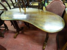 A MAHOGANY KIDNEY SHAPED SIDE TABLE with glass top on rectangular block supports, with swept