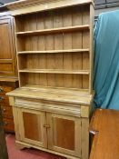 A VICTORIAN PINE DRESSER/BOOKCASE CONVERSION with inverted shaped cornice over four open shelves,