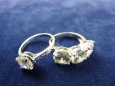 A WHITE METAL DRESS RING WITH CZ SOLITAIRE and a 925 silver dress ring with three large equal czs